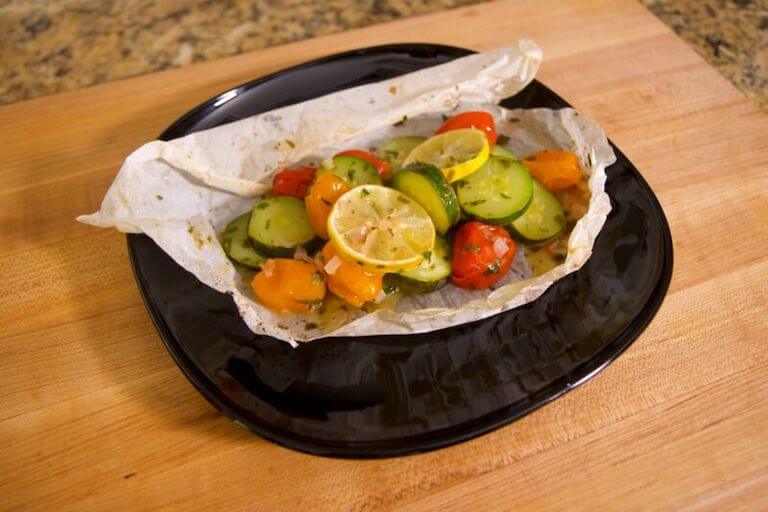 Cucumber, lemon, and other vegetables on a black plate