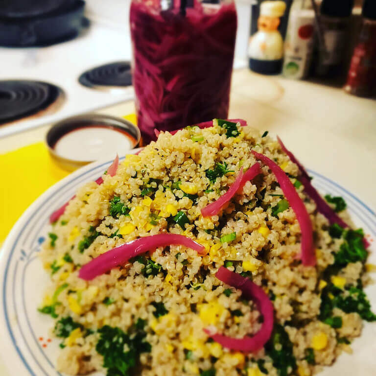 Fresh quinoa salad topped with homemade pickled red onions