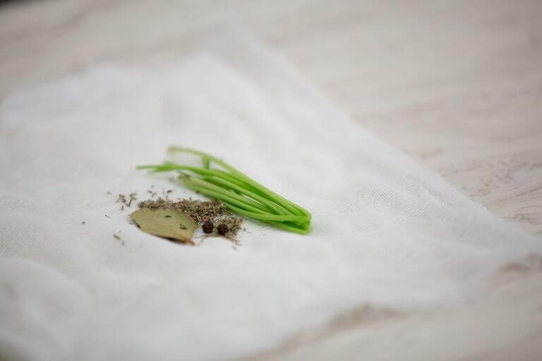 Herbs sitting on an open white sachet 