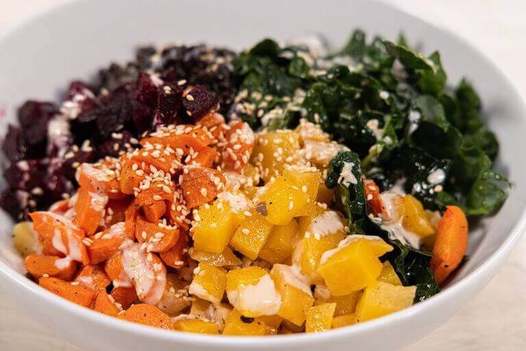 Plant based bowl with carrots, spinach, and other vegetables