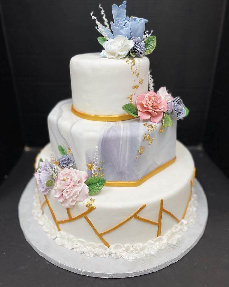 Three tier cake with white marble frosting made by Escoffier Austin pastry arts student