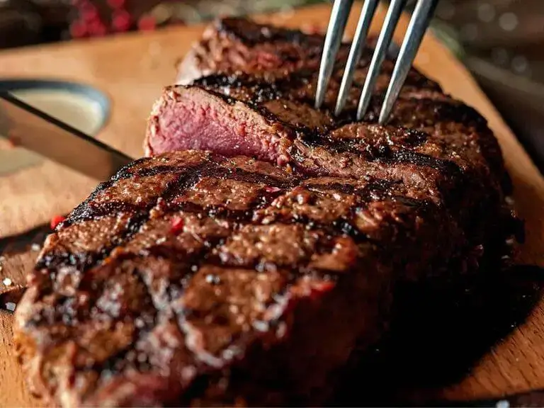 Sliced seared steak with fork.