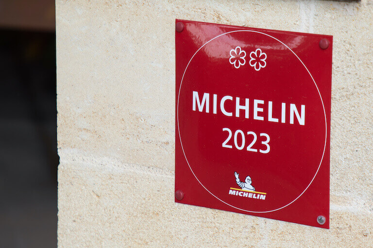 A red Michelin star plaque on a concrete wall.