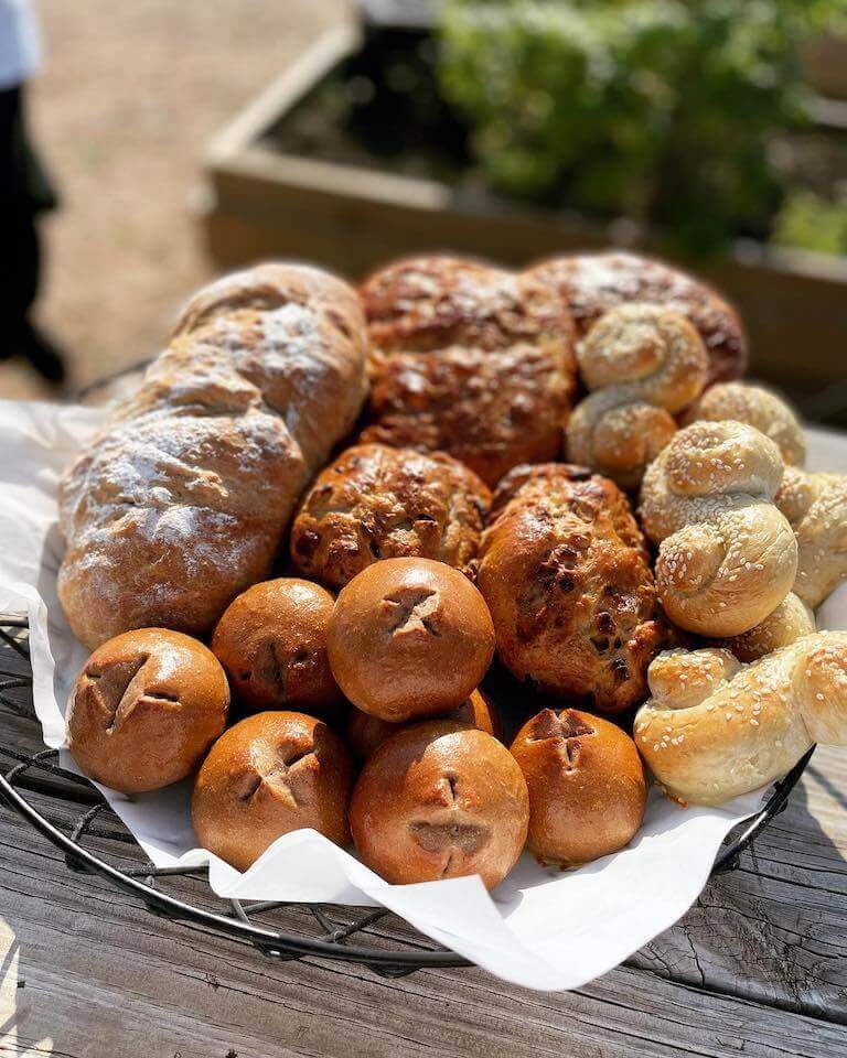 Mixed breads displayed in a wire basket outside