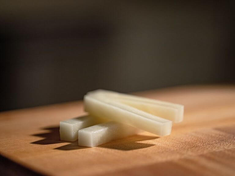 Russet potato slices on a wooden board