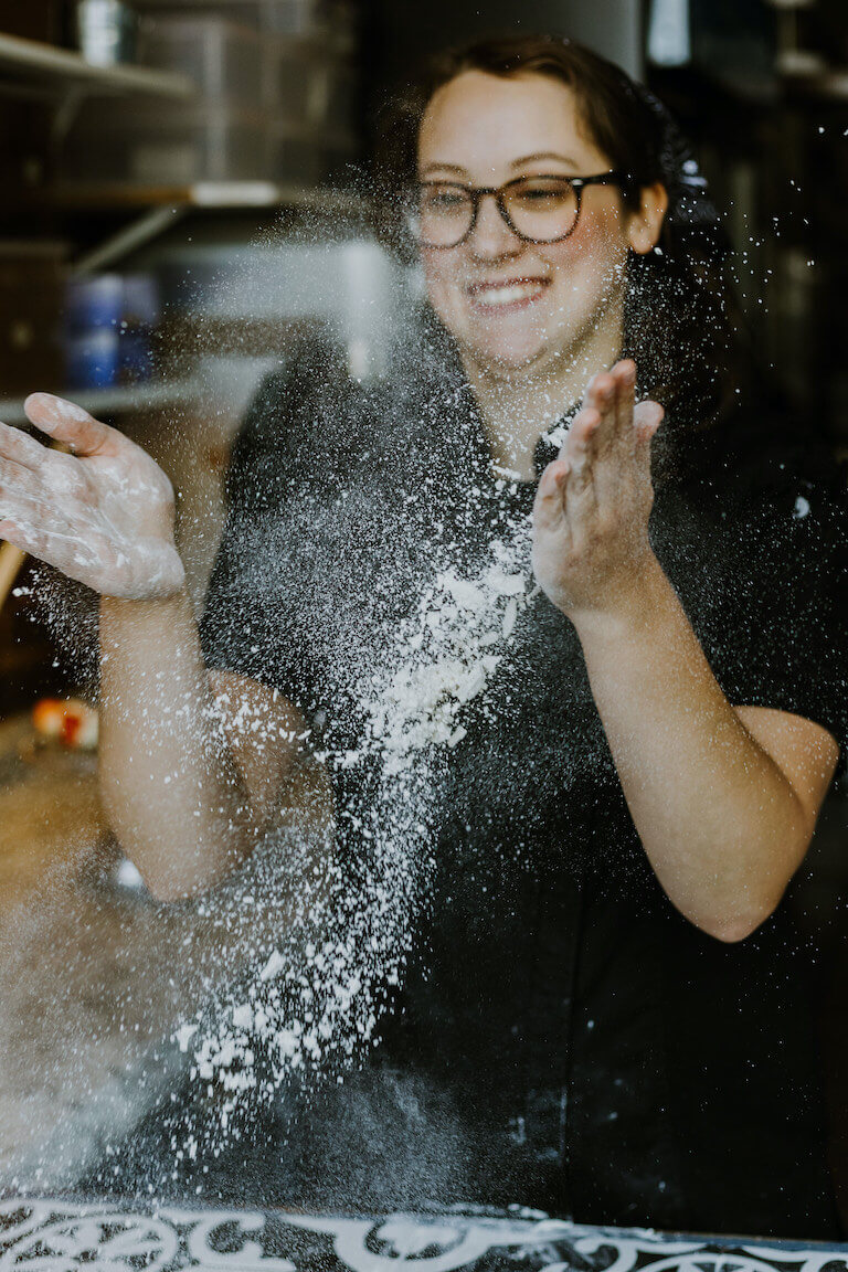 Cassie in uniform tossing flour