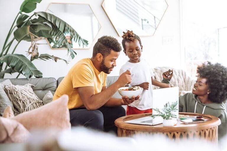 Family of three eating in the living room