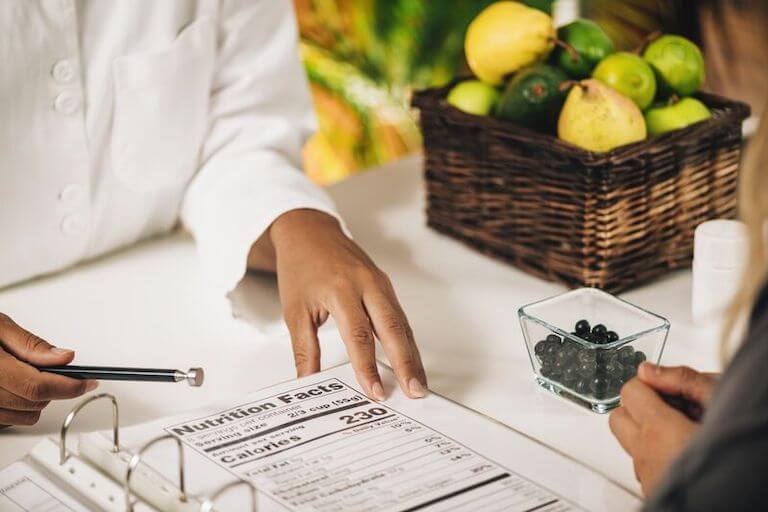 Nutritionist showing patient nutrion facts label printed on a piece of paper