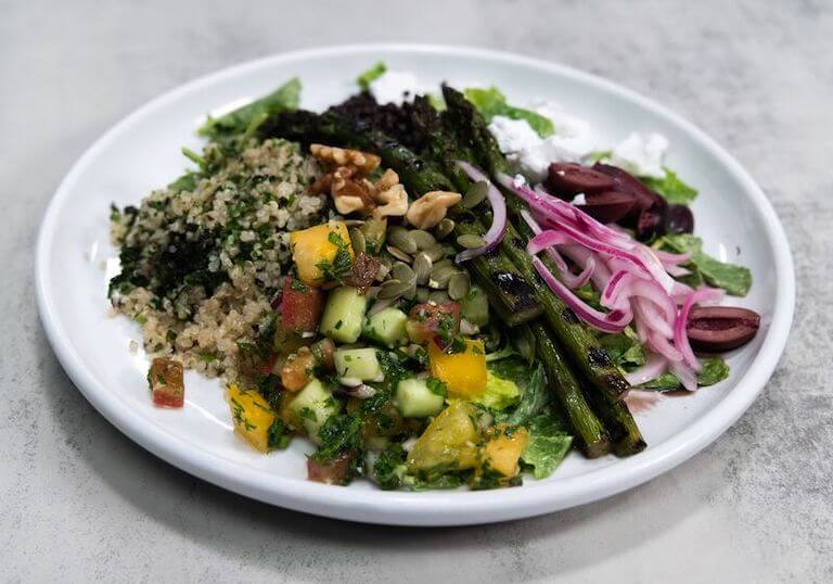 Onions, asparagus, and other vegetables in a white bowl