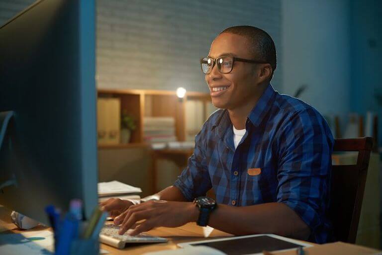 Person sitting at a desk typing on a computer