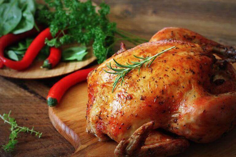 Whole roasted chicken on a wooden board