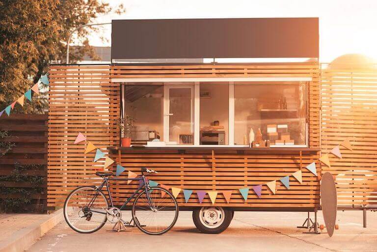 Food truck with a bicycle and skateboard leaning against it