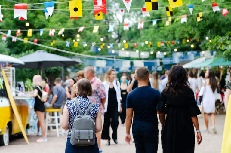 Large crowd of people at a festival with food trucks