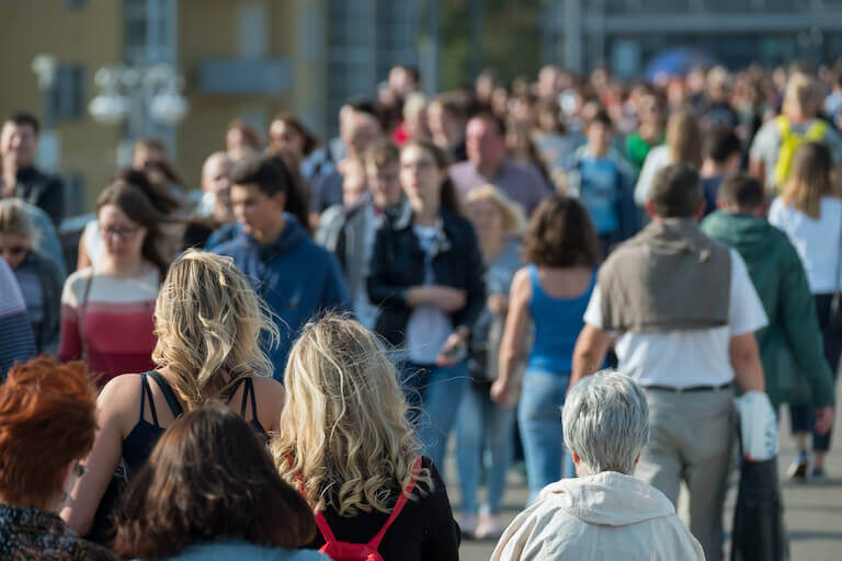 Large crowd of people walking down the street