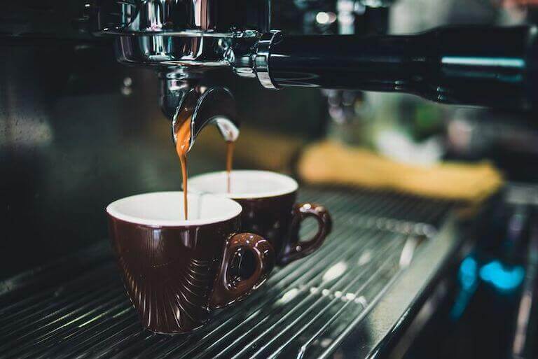 Espresso Machine pouring espresso into two brown cups