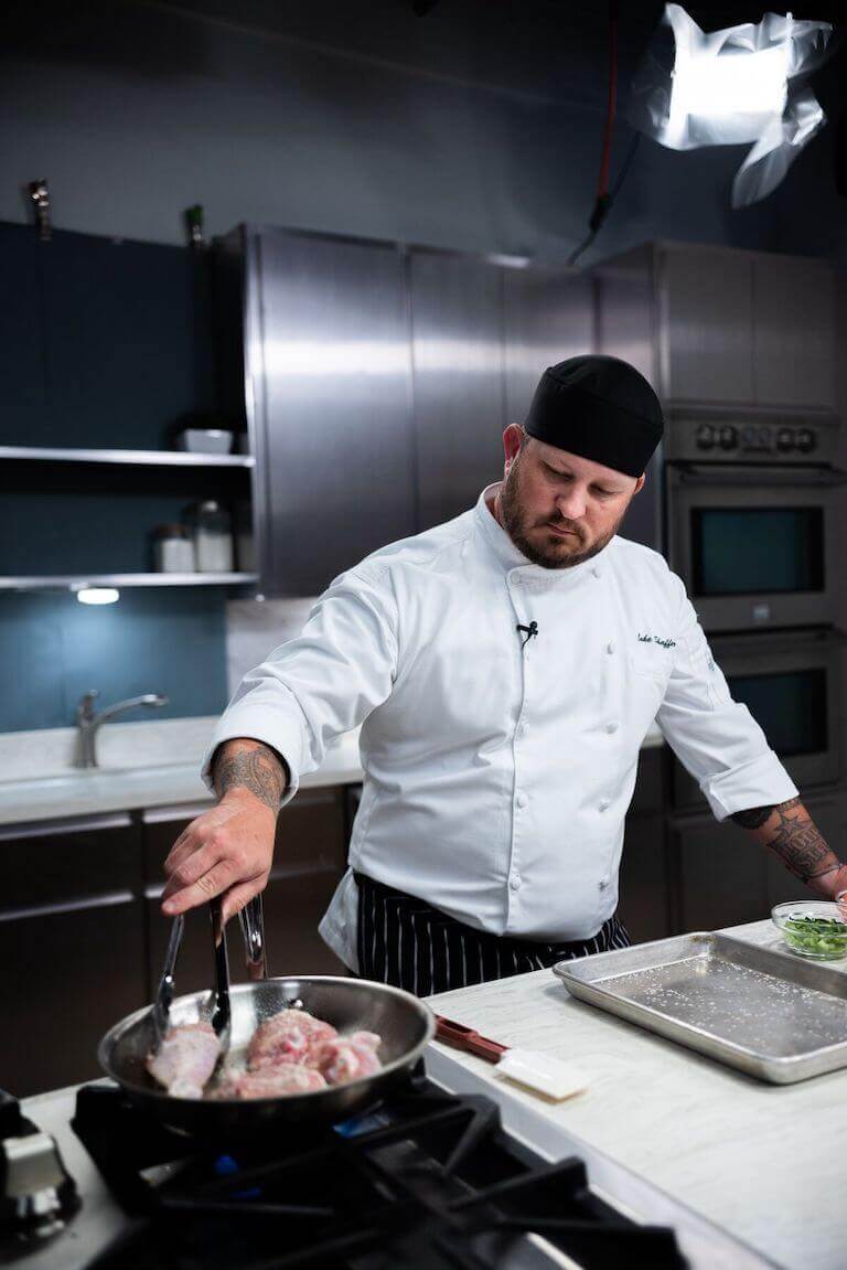 Chef in uniform cooking chicken