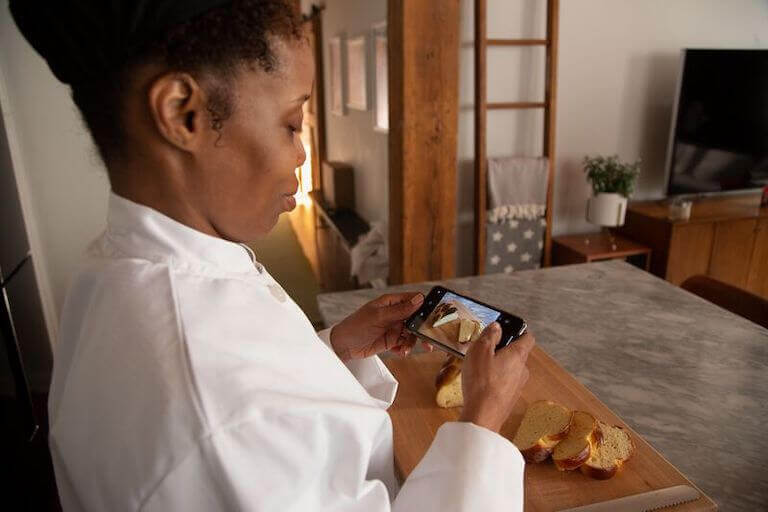 Online student taking a picture of fresh bread with a phone