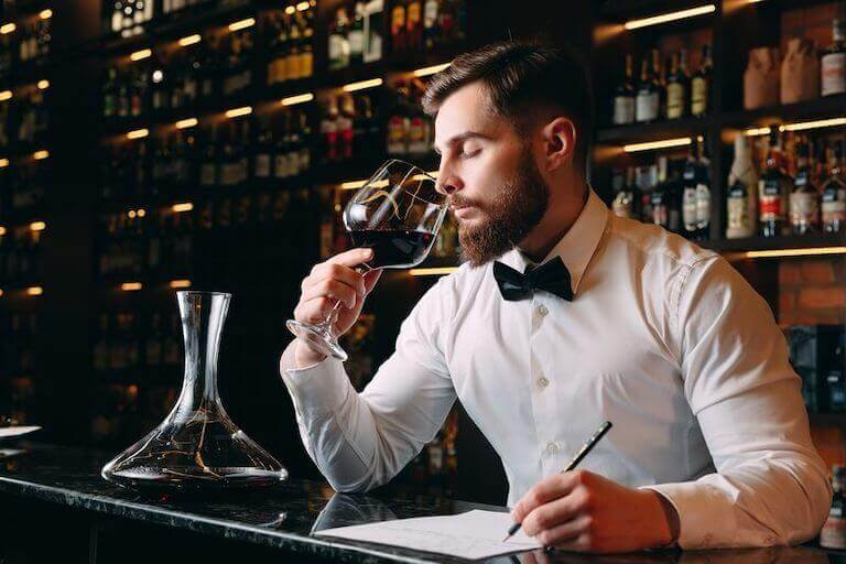 Sommelier smelling wine in a wine cellar