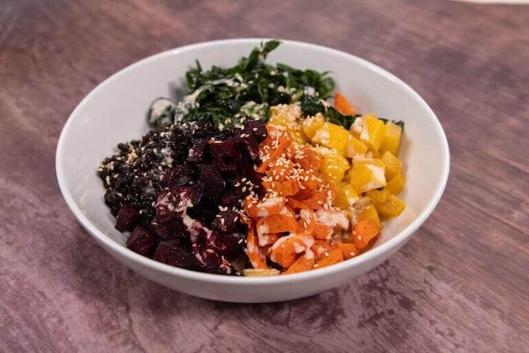 Plant based bowl with carrots, spinach, and vegetables