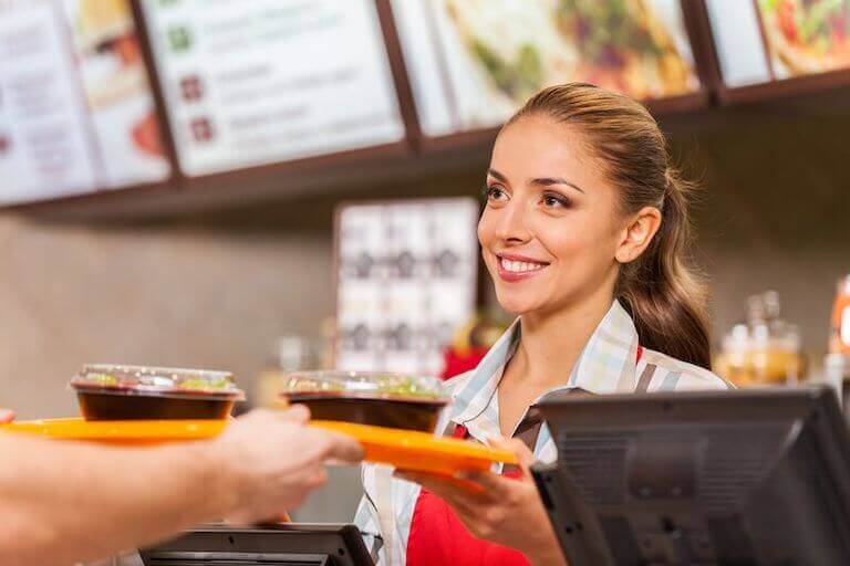 Restaurant worker handing an orange tray with food to a customer