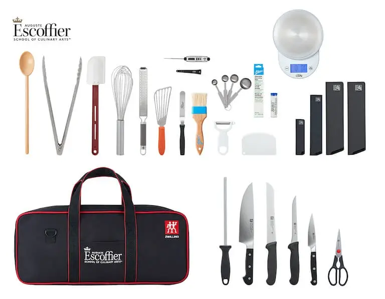 Escoffier online culinary toolkit laid out showing black knife roll bag, digital scale, thermometer, professional knives, high temp spoon, peeler, piping tips, and measurement tools.
