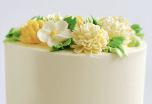 White Chocolate Buttercream cake with yellow flowers and green leaves