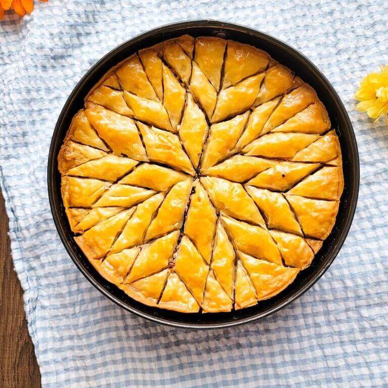 Baklava in a pan on a blue and white cloth
