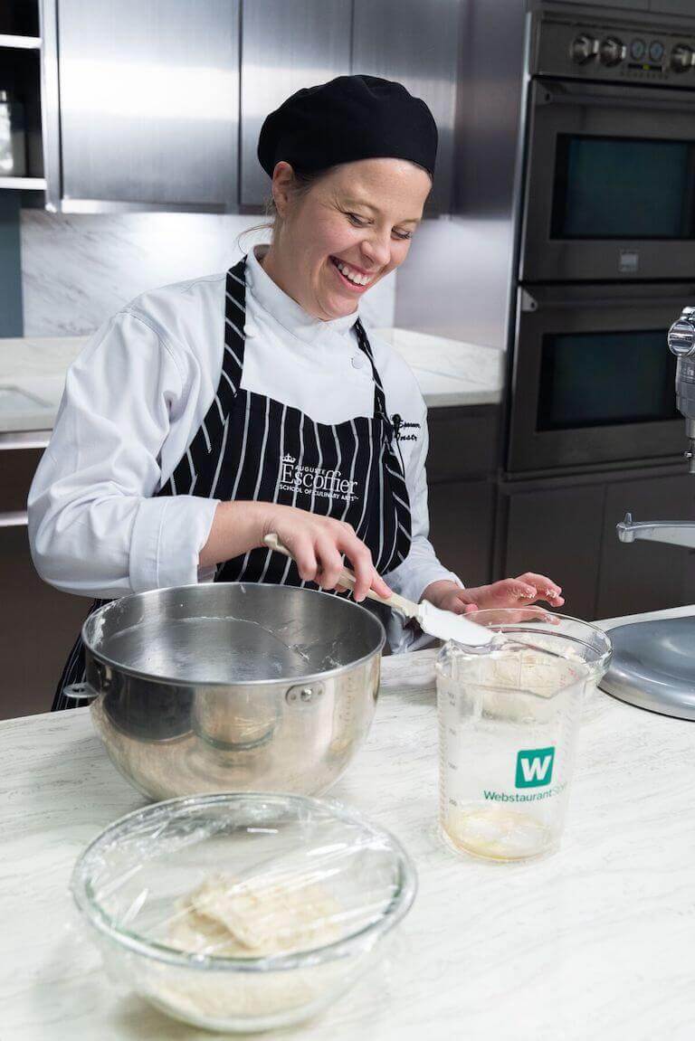 Chef smiling in a kitchen making flat bread dough