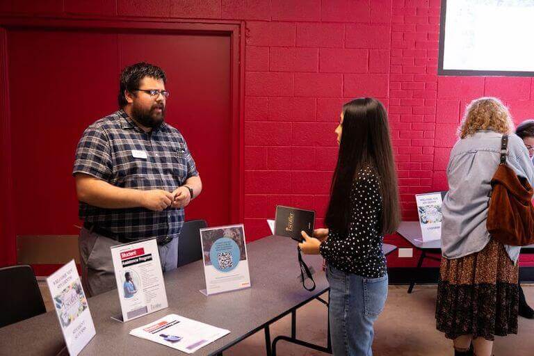 Escoffier student at a networking event talking to someone at a table