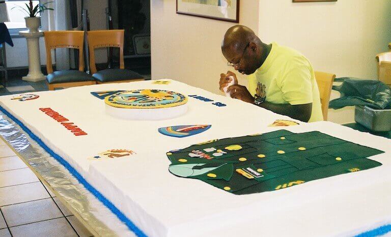 Chef Eric decorating a large cake for the 229th Army Birthday celebration