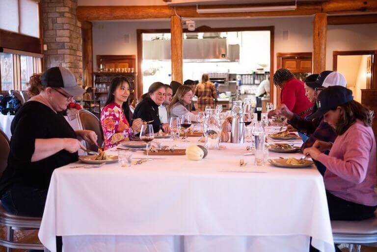 Group of people eating at a long table in a restaurant