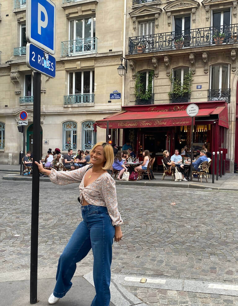 Suhalia smiling for a photo next to a street in Paris