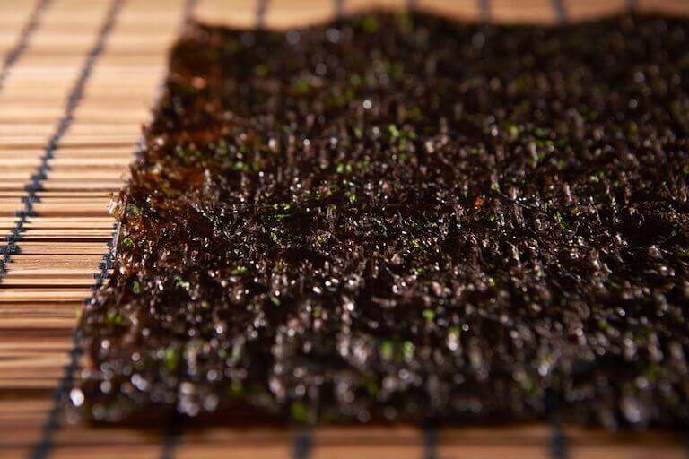 Dried seaweed laying flat on a bamboo mat