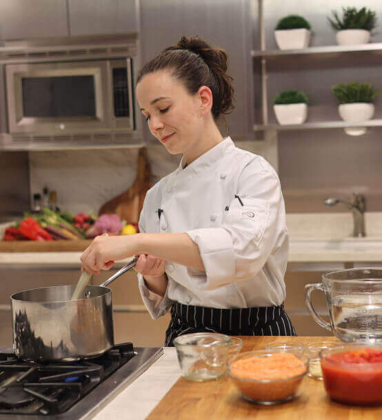 Plant-based chef stirring a pot in a kitchen