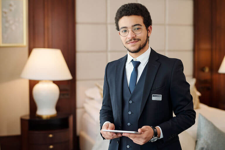 Hotel manager standing in a room holding a tablet