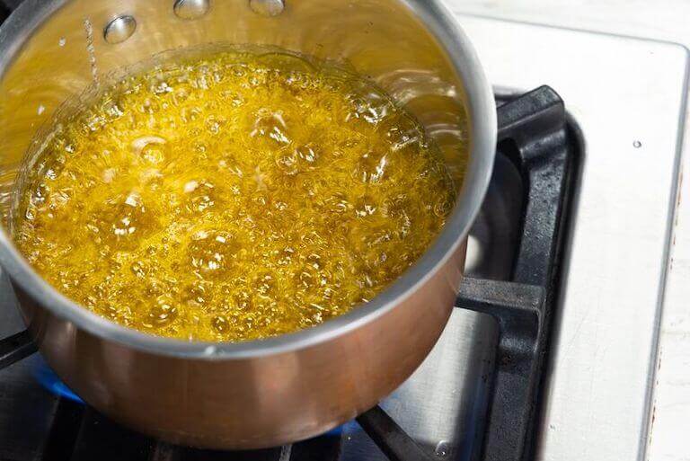Yellow hard candy boiling in a pot