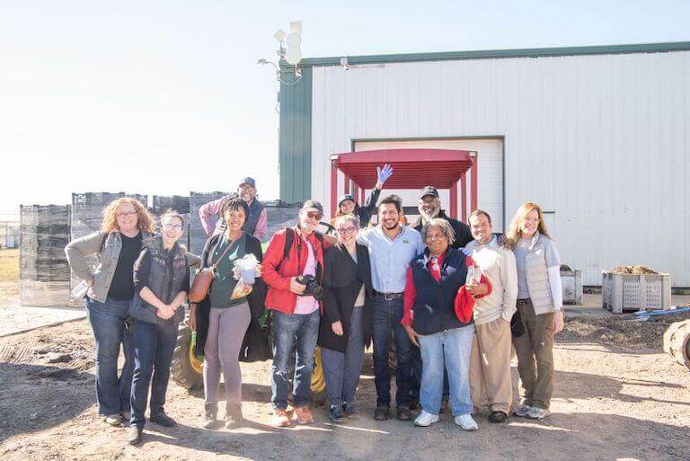 Smiling students and faculty at an Escoffier event located at a farm.