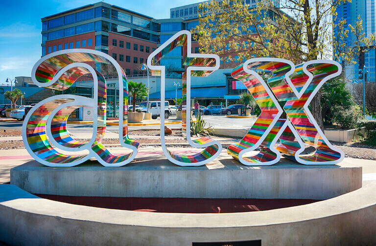 An art installation in Austin, TX consisting of large, colorful lower-cast letters A, T, and X.