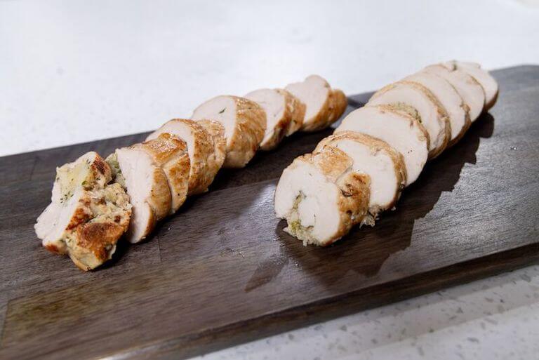 A closeup of turkey roulade slices on a wooden platter.
