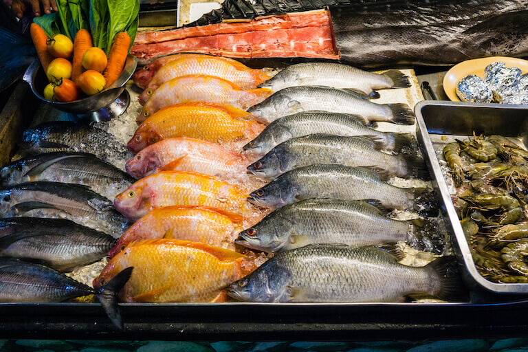 Fresh fish neatly stacked facing the same direction in a tray of ice