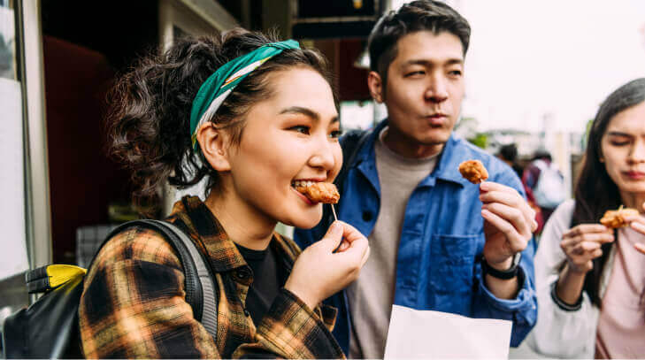 A group of foodies tasted karaage chicken bites on toothpicks during a food tour