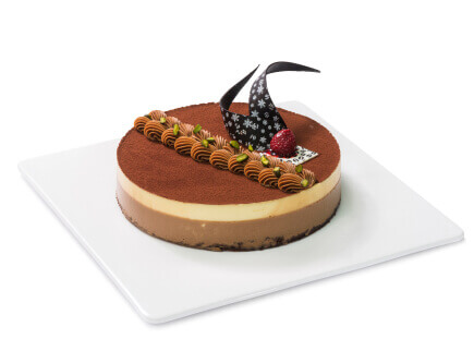 A chocolate mousse tart with decorative berry topping on a white plate
