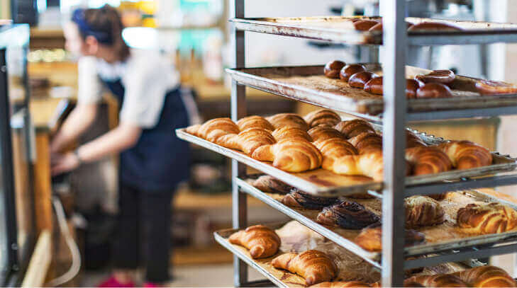 Stacks of trays carrying croissants in a bakery