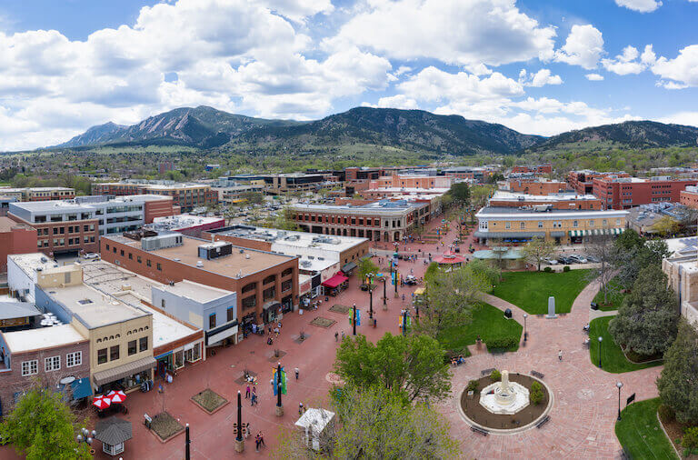 An aerial view of a brick pedestrian mall, lined with shops and streetlamps. 