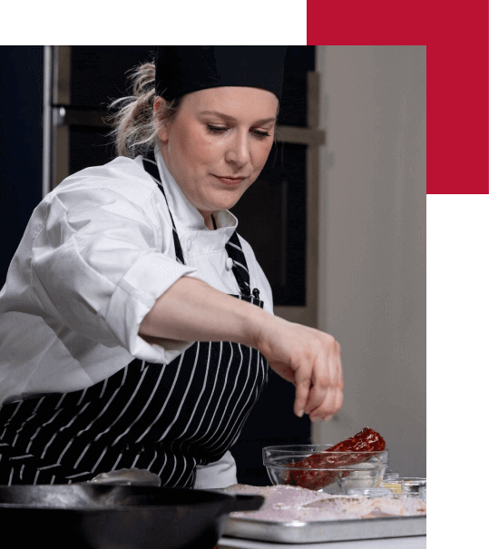 An Escoffier online Chef Instructor seasoning BBQ ribs