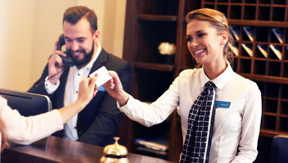 A hotel manager checks in guests at the hotel's front desk