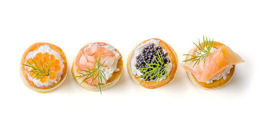 Four puff pastries with salmon caviar and shrimp