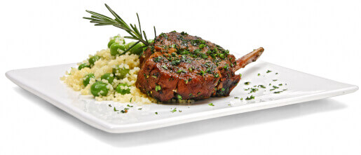 A lamb chop with couscous and rosemary on a white square restaurant plate
