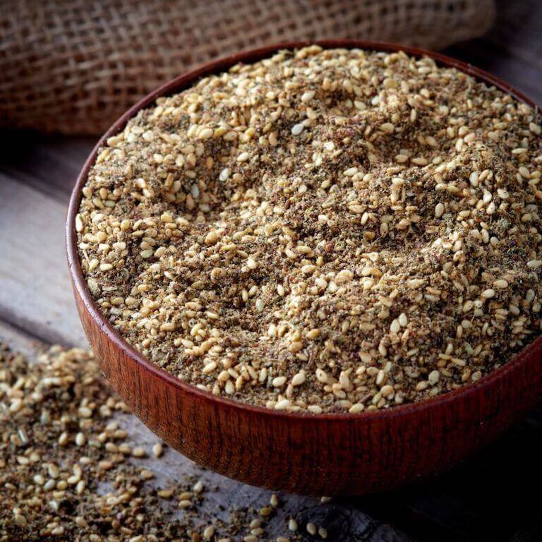 A wooden bowl full of sesame seeds and the ground herbs and sumac berries that make Za’atar.