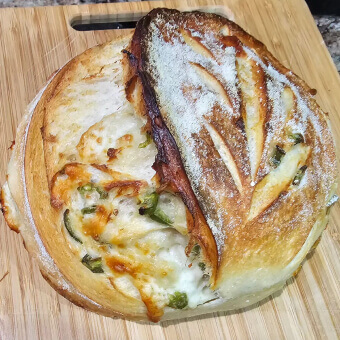 Artisanal bread baked by an Escoffier student sitting on a cutting board